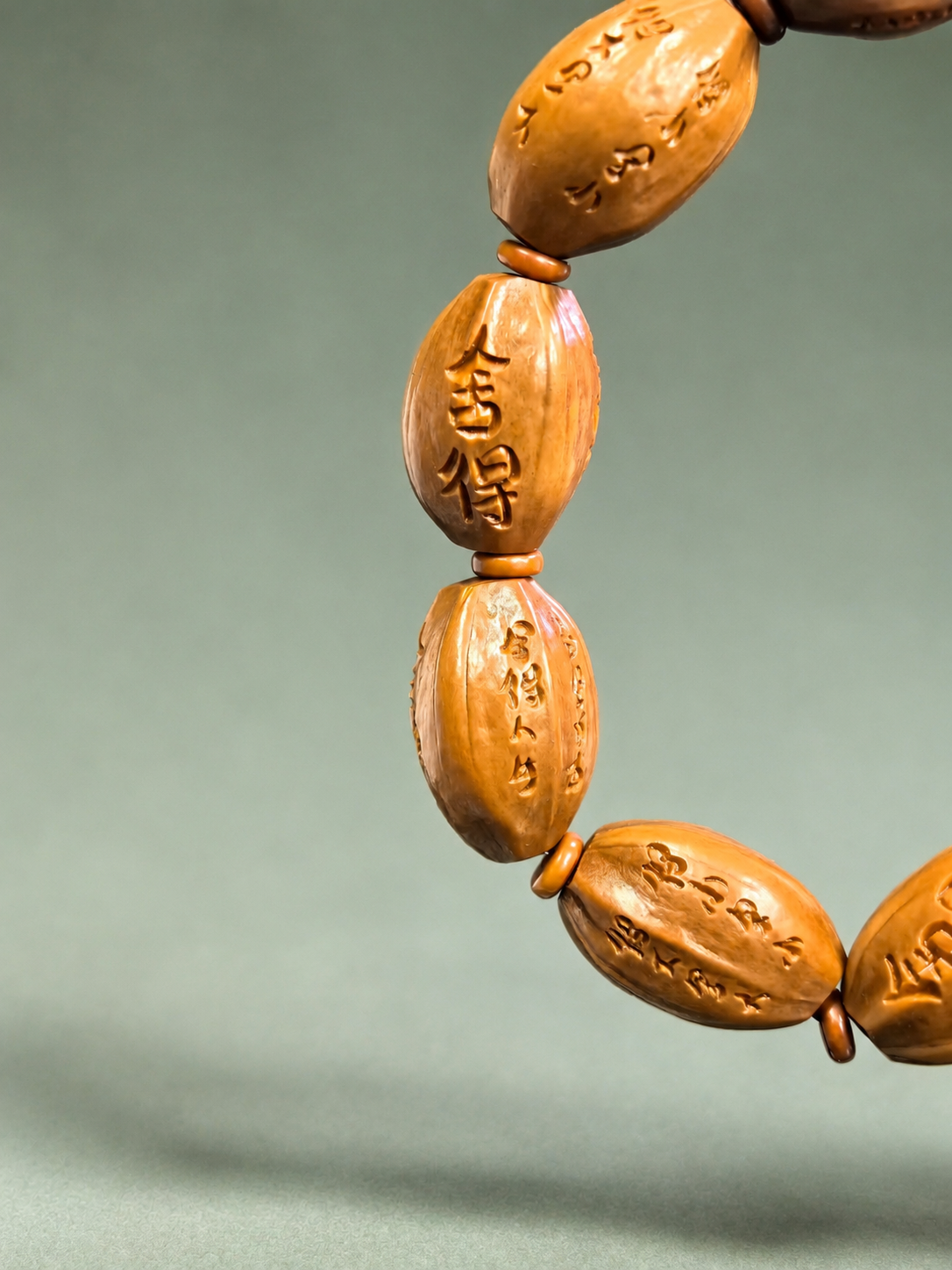 Carved olive pit calligraphy bracelet with "She De" design, 15.5mm beads, featuring traditional blessing symbols.