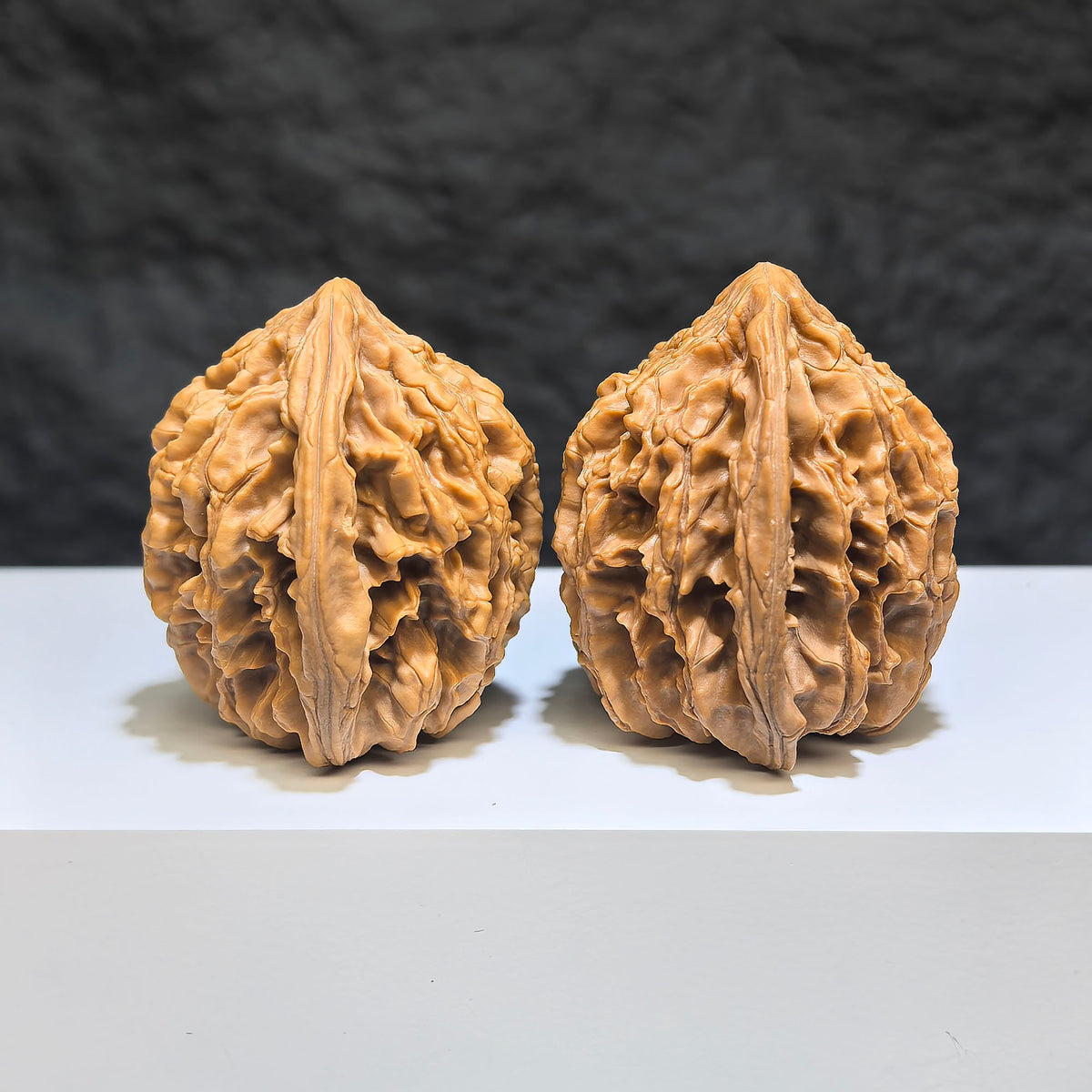 Pair of Tongtian Eight Wenwan walnuts by Wenwan Art, 40mm x 37mm, showcasing smooth, polished walnut carvings.