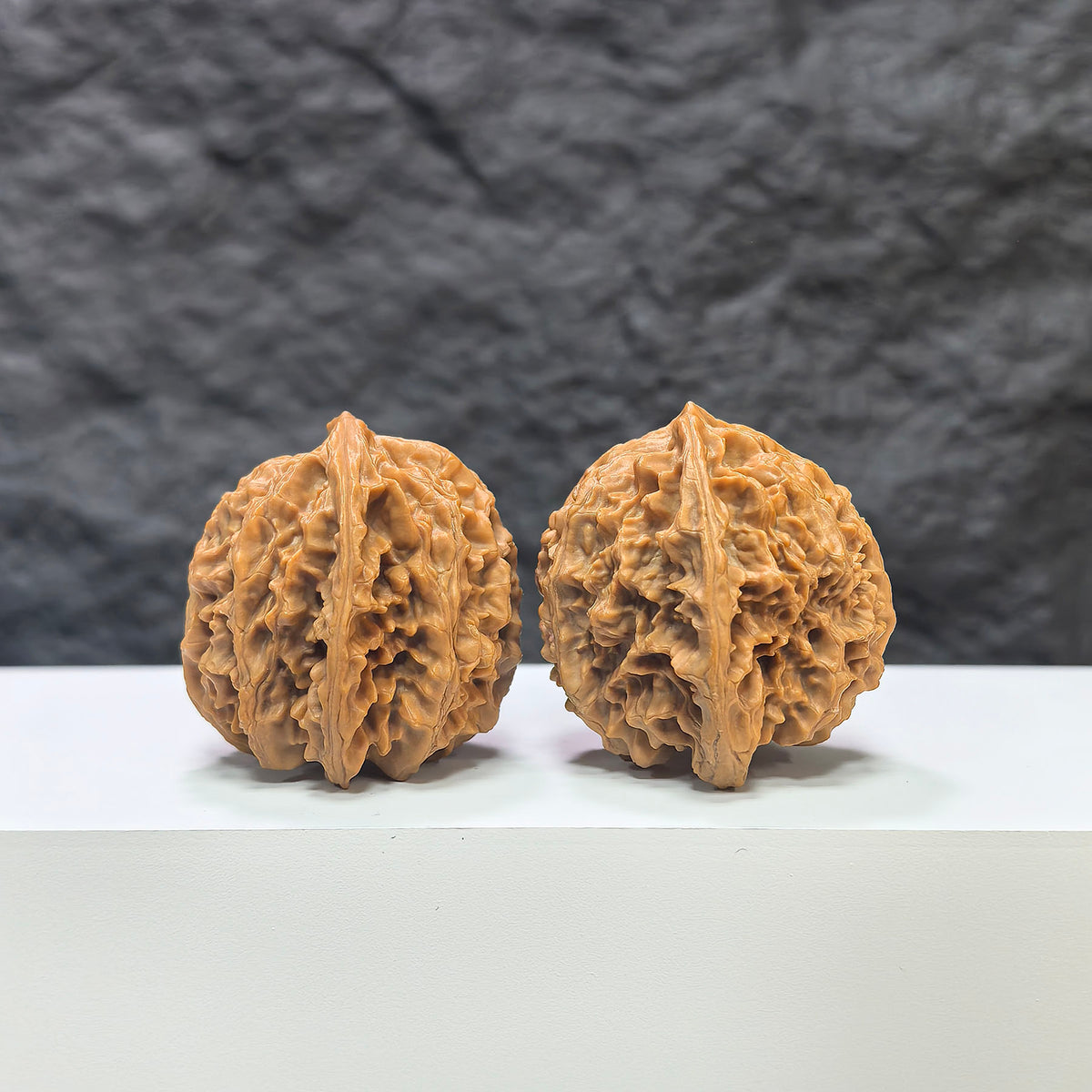 Pair of Wenwan Art Apple Garden Peach Heart Concave Base walnuts with deep, smooth surface and natural wood grain details.
