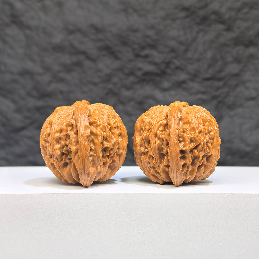 Pair of Wenwan Art Millstone Classic Wenwan Walnuts, 37mm x 35mm, featuring detailed carvings on smooth walnut surfaces.