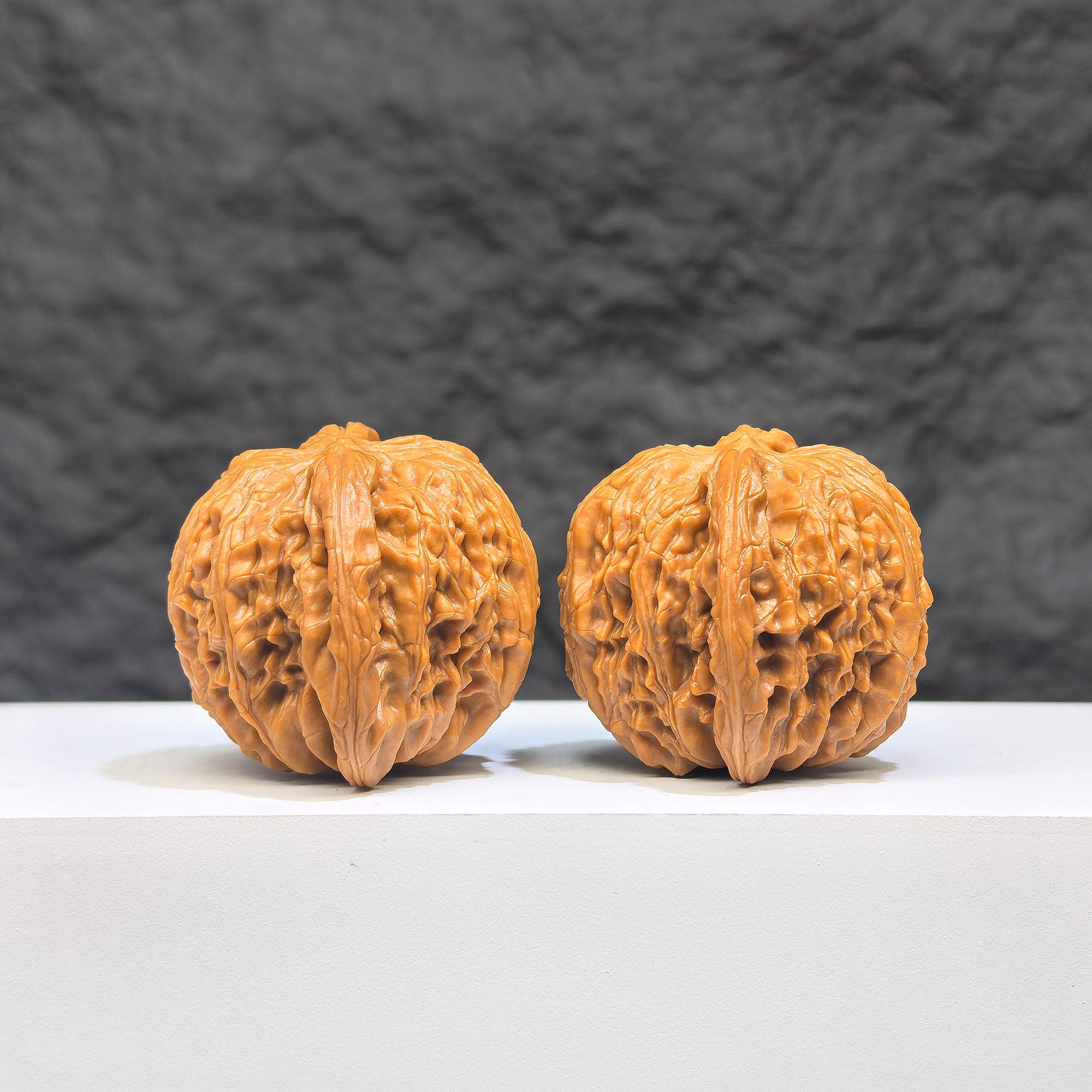 Pair of Wenwan Art Millstone Classic Wenwan Walnuts, 37mm x 35mm, featuring detailed carvings on smooth walnut surfaces.