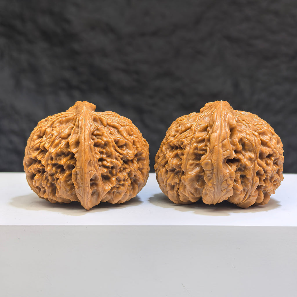 Pair of spherical Nanjiangstone Wenwan walnuts from Wenwan Art, round-profile with 41mm and 43mm diameter, detailed stone surface.