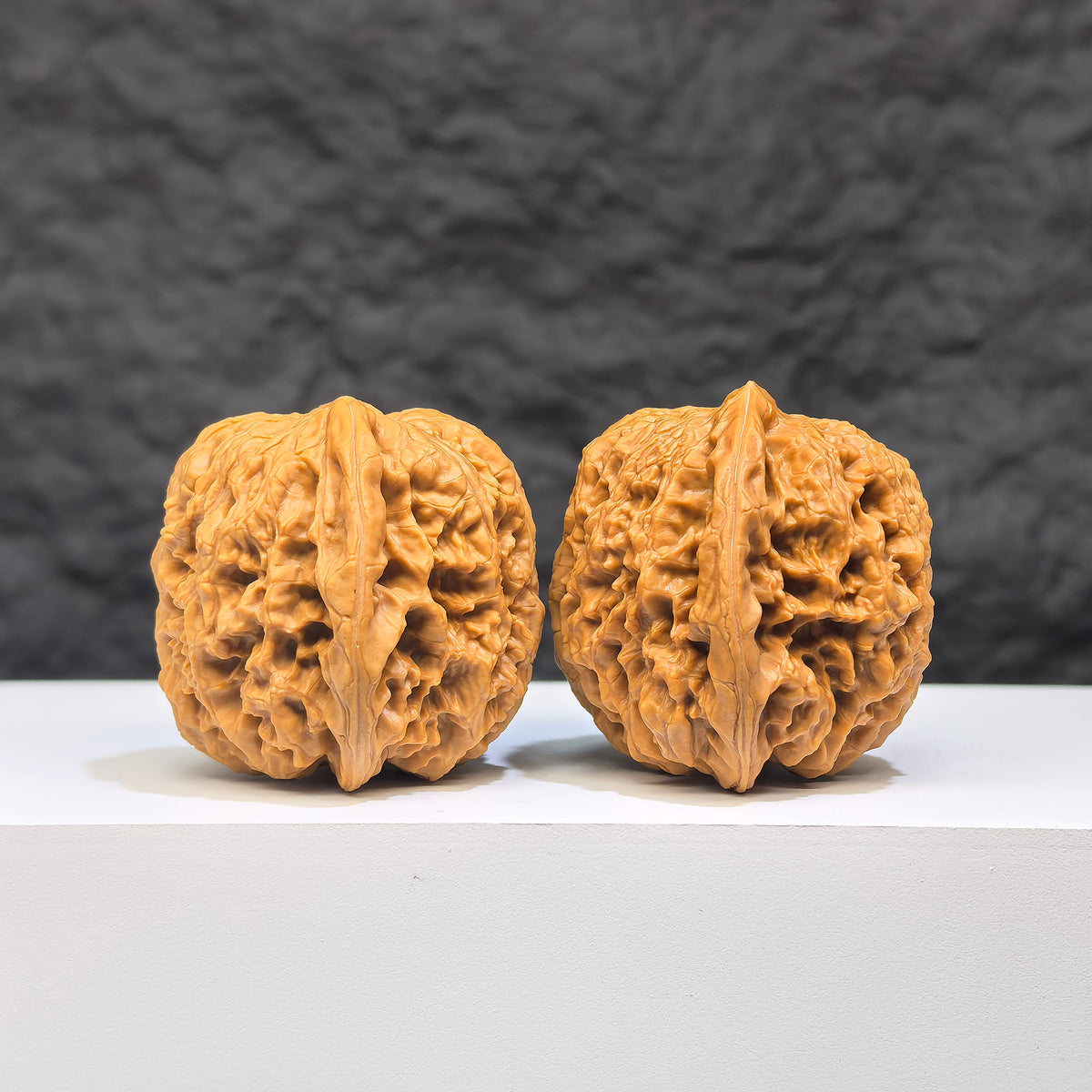 Pair of Yuhua Stone Wenwan walnuts from Wenwan Art, 37mm x 34mm, showcasing their unique textures and natural stone patterns.