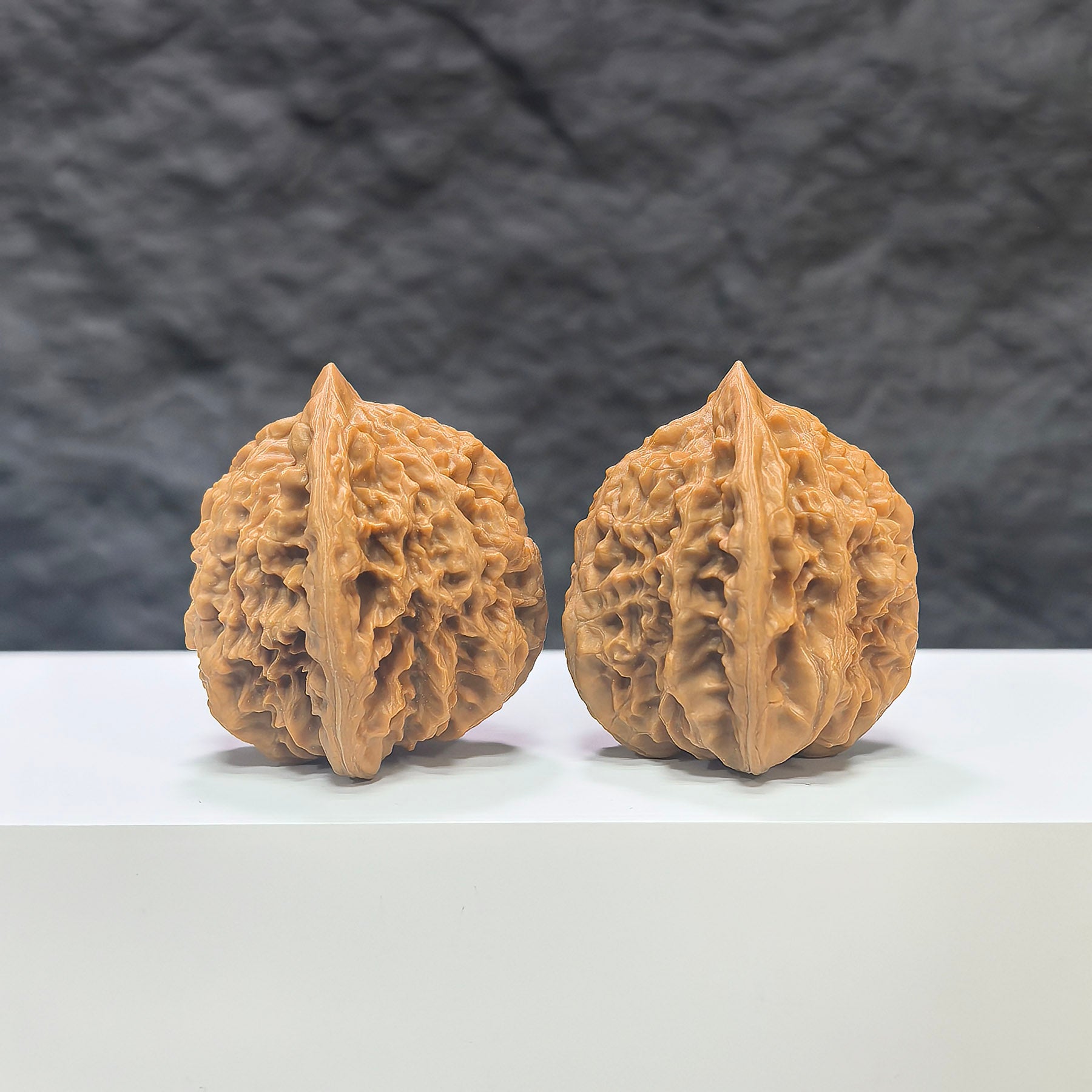 Pair of Peach Heart Xiayunling Wenwan walnuts from Wenwan Art, showcasing smooth, rounded walnut surfaces with peach and cloud-like patterns.