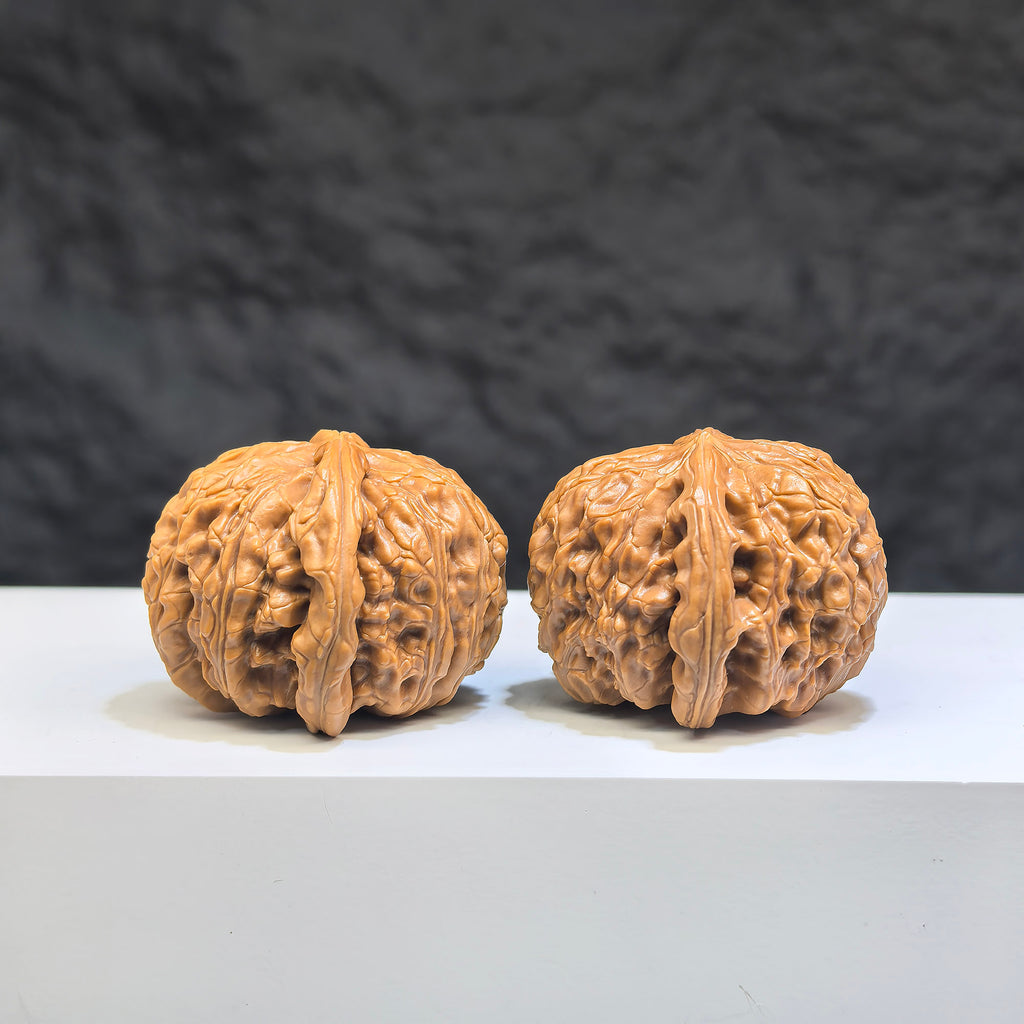 Pair of white lion Wenwan walnuts with spherical shape, 35mm, showcasing detailed craftsmanship and smooth round profiles.