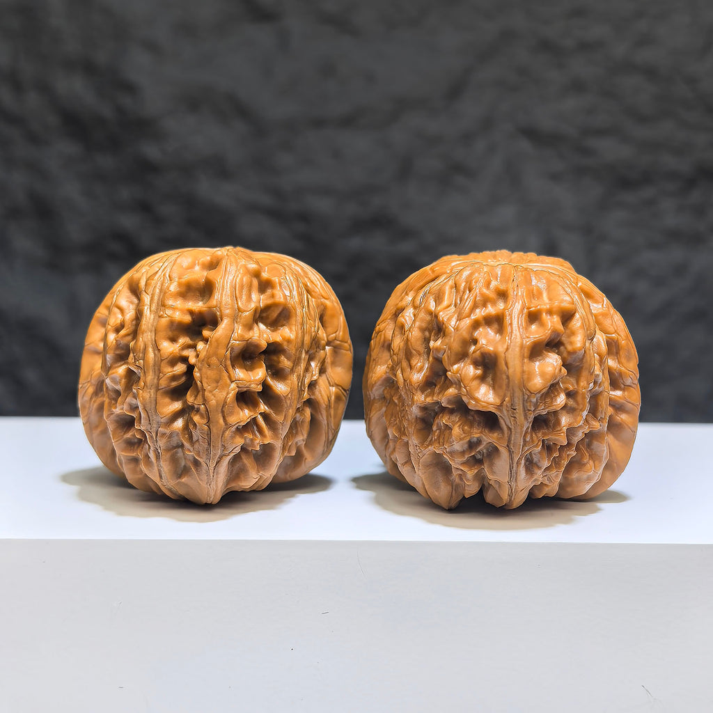 Pair of Pinggu Sycee Yuanbao-shaped Wenwan walnuts from Wenwan Art, 39mm x 46mm, featuring intricate carved details.