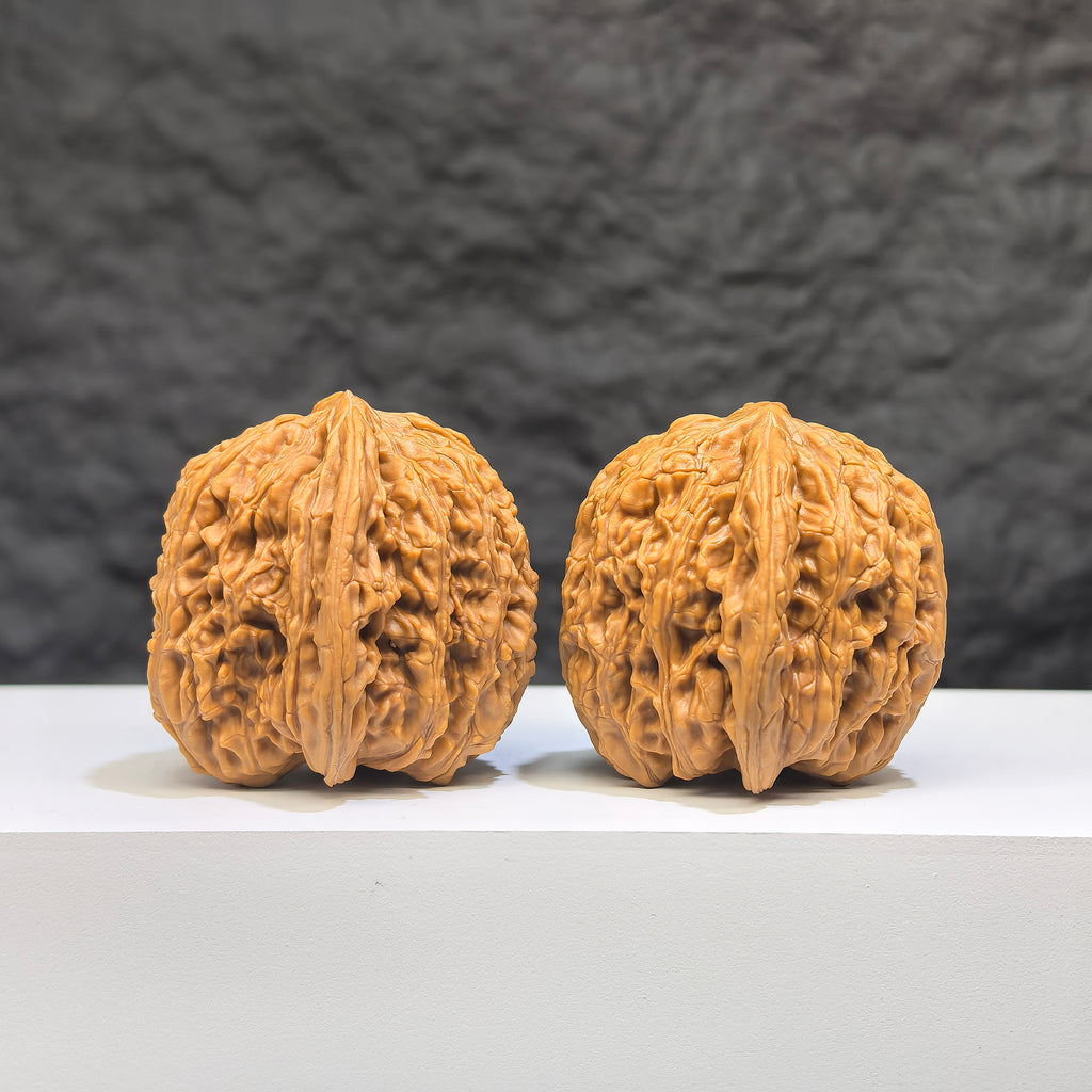 Pair of Wenwan Art "Ruby" Classic Wenwan Walnuts, 36mm, featuring rich red stone with intricate natural patterns.