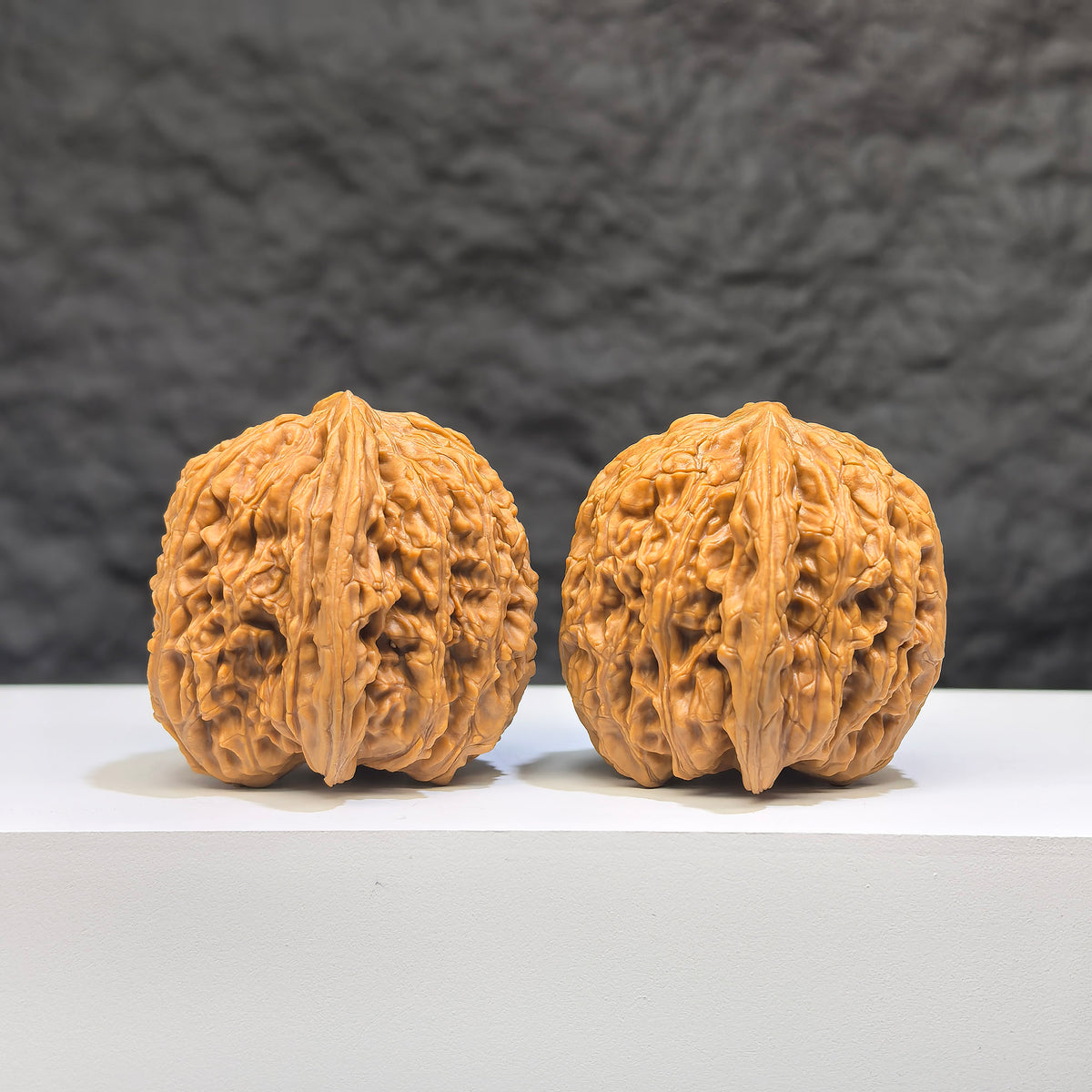 Pair of Wenwan Art "Ruby" Classic Wenwan Walnuts, 36mm, featuring rich red stone with intricate natural patterns.