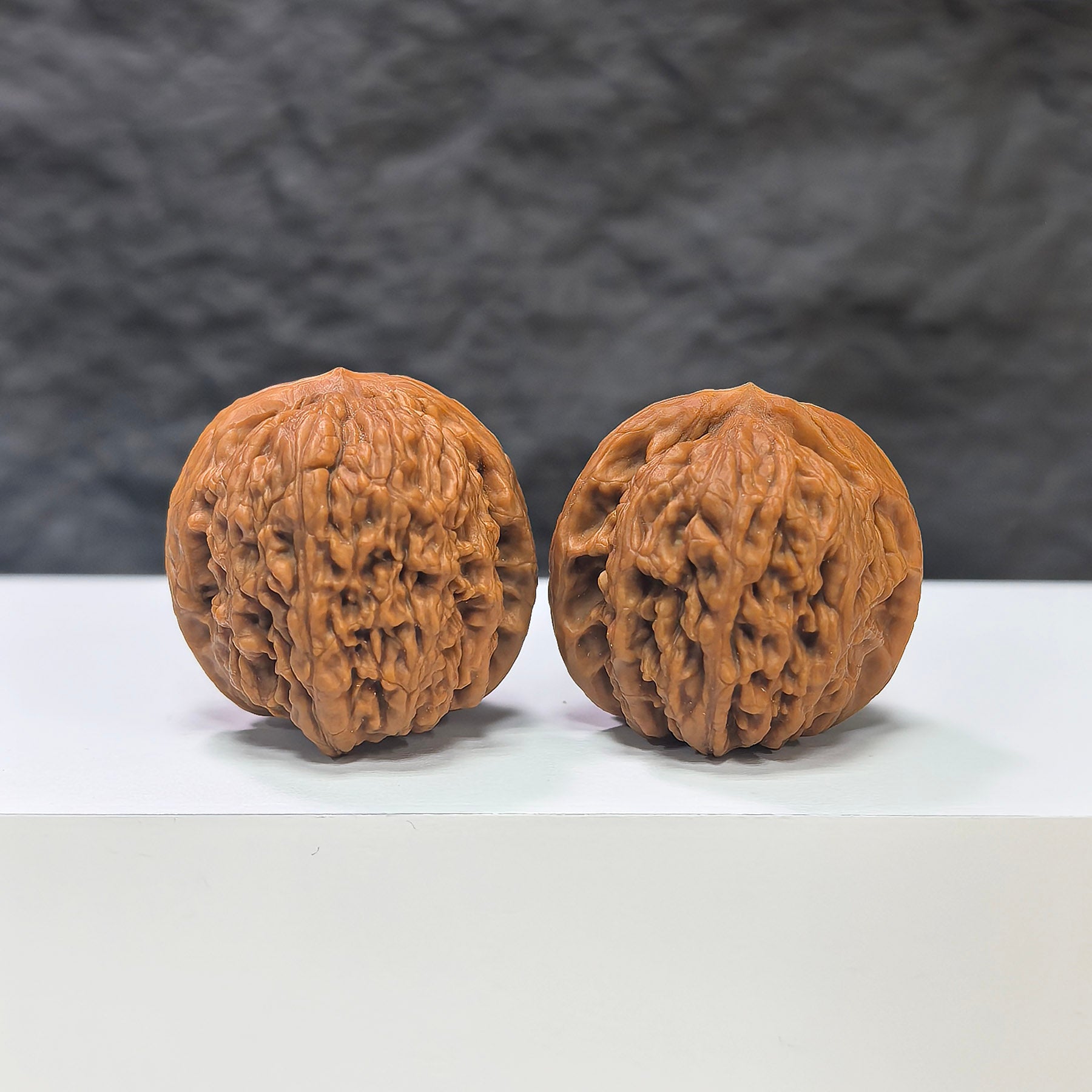 Pair of Nuwa Stone Wenwan walnuts from Wenwan Art, 38mm x 37mm, natural stone with intricate textures and polished surface.