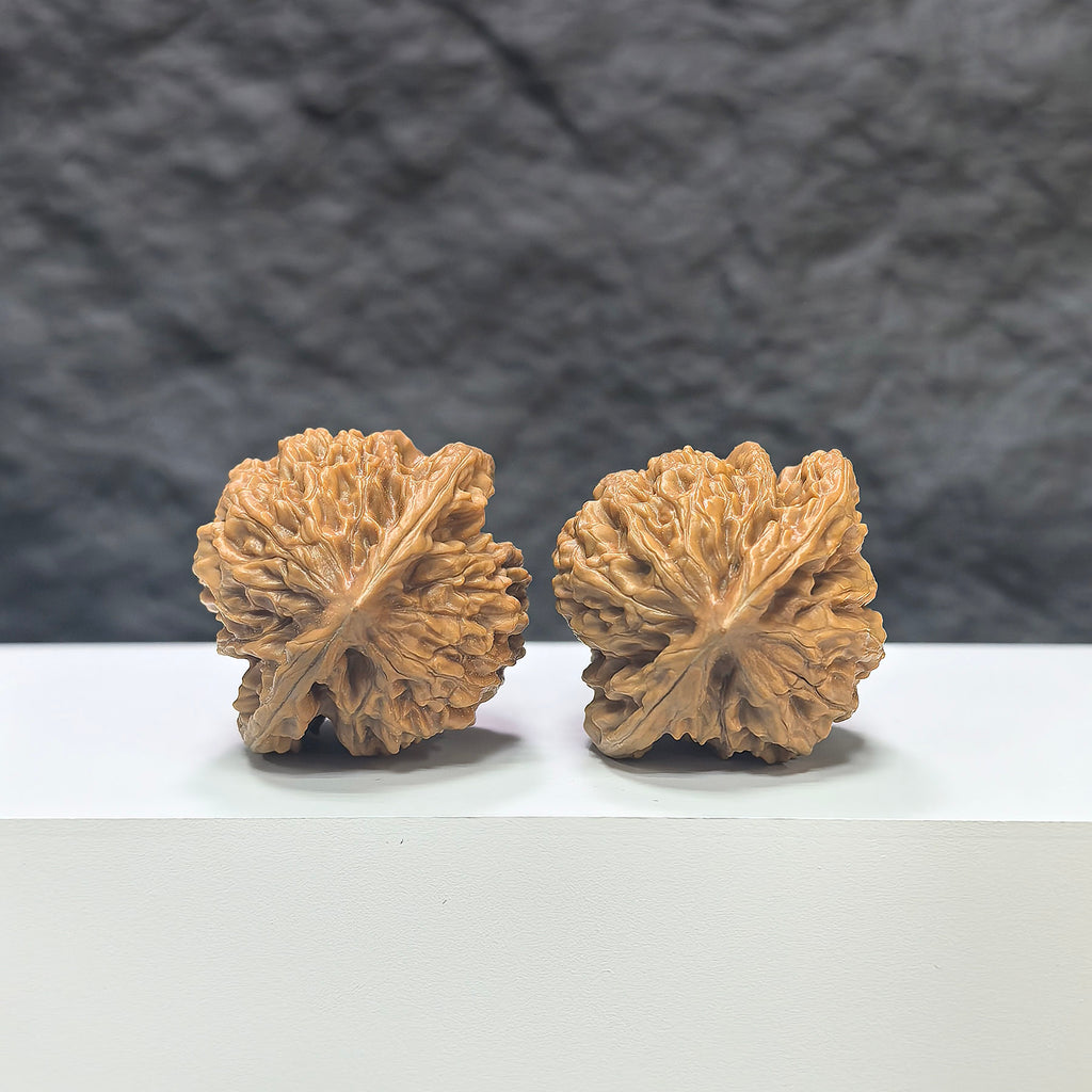 Pair of Peach Heart Xiayunling Wenwan walnuts from Wenwan Art, showcasing smooth, rounded walnut shells with peachy hues and natural textures.