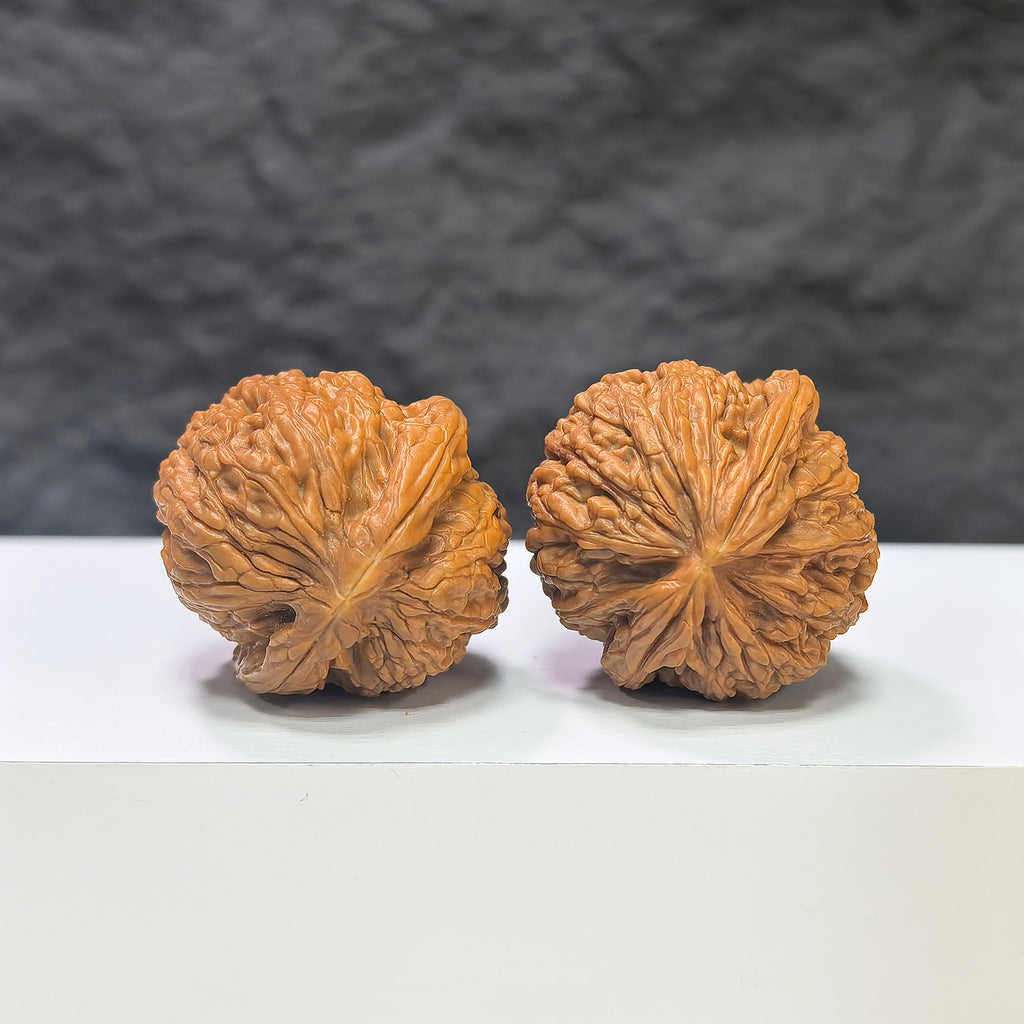Miniature Wenwan Walnut pair featuring pocket meteorite sycee carvings, from Wenwan Art, measuring 31mm each.