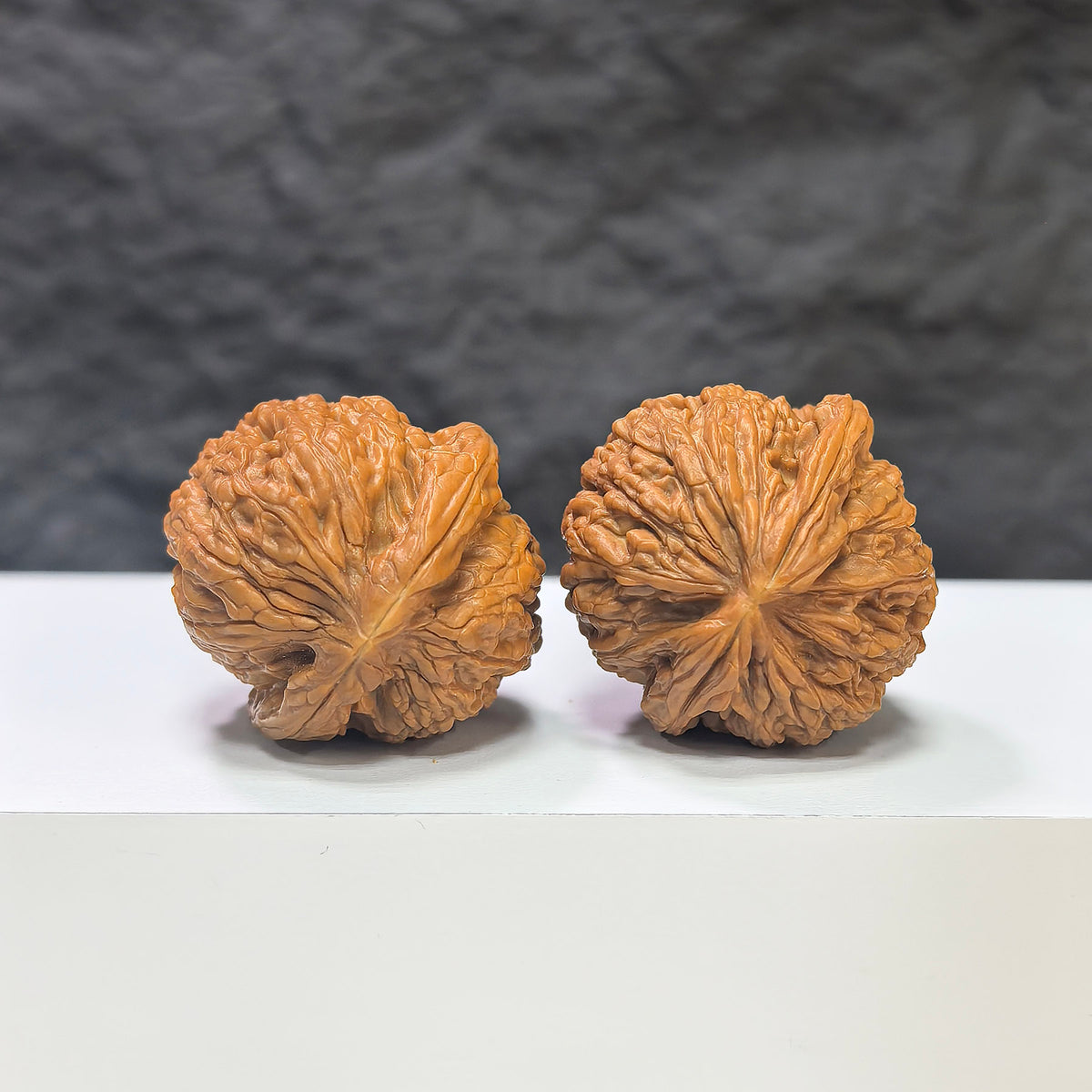 Miniature Wenwan Walnut pair featuring pocket meteorite sycee carvings, from Wenwan Art, measuring 31mm each.