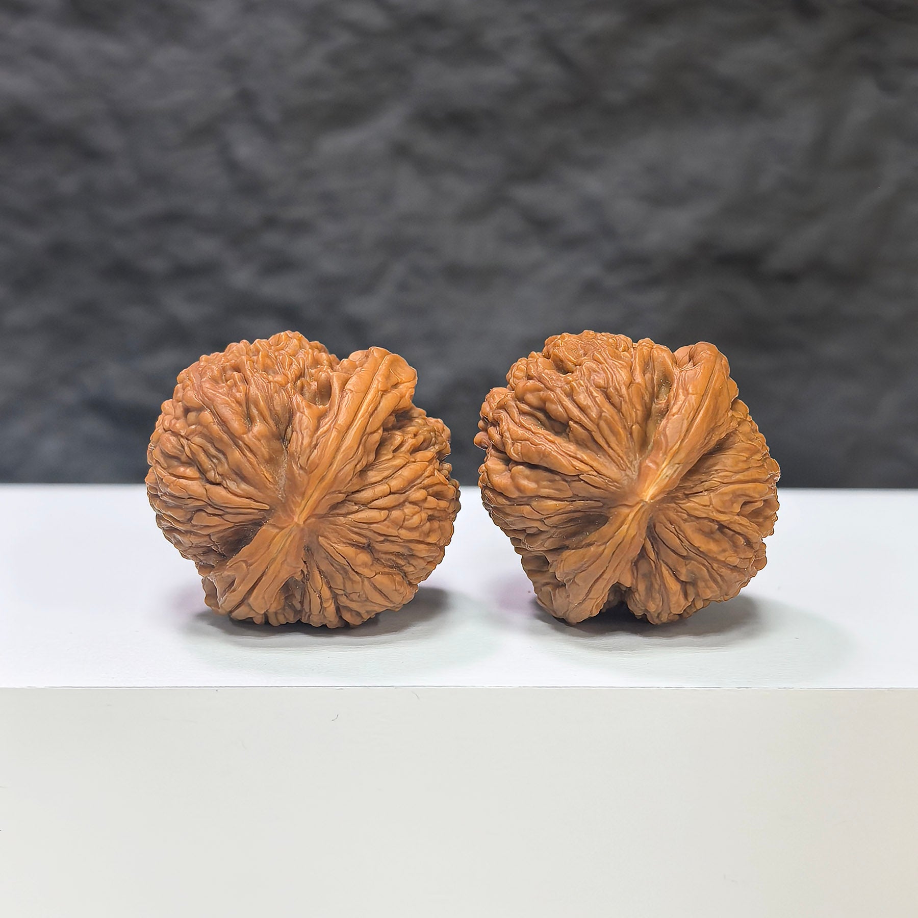 Pair of Meteorite Sycee Wenwan walnuts from Wenwan Art, 30mm each, showcasing natural stone patterns and smooth polished surfaces.
