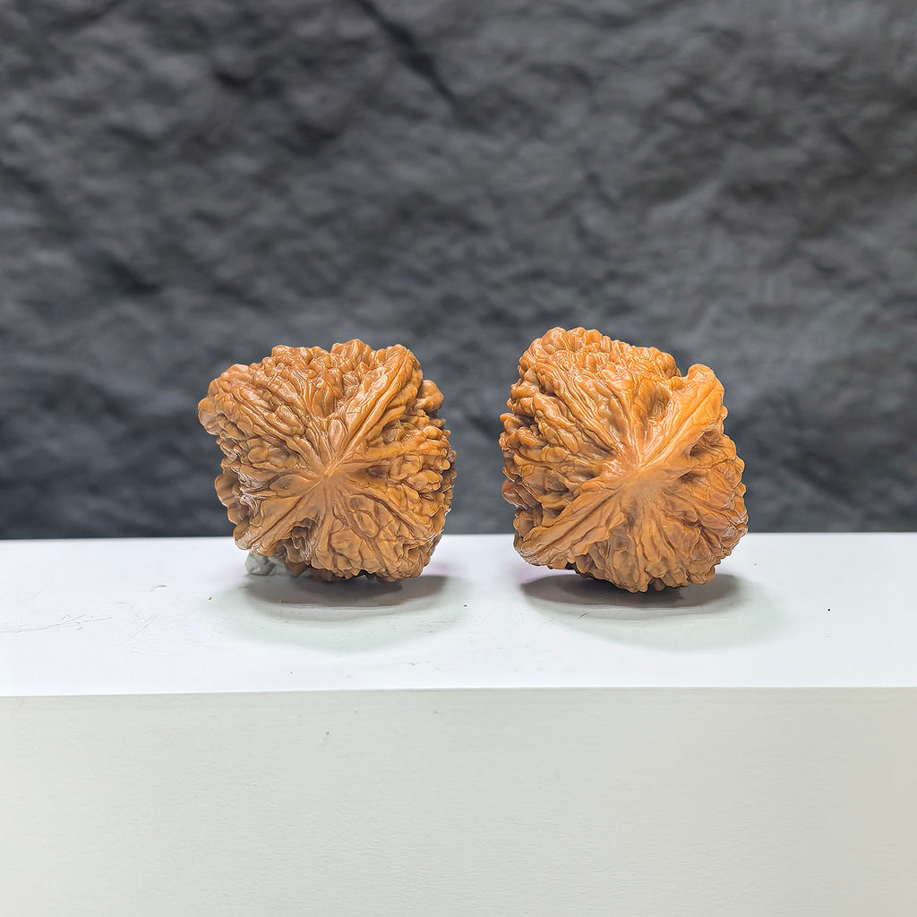 Pair of Pinggu Concave Base Wenwan walnuts by Wenwan Art, deep-base walnuts measuring 33x37mm, showcasing smooth, polished wood.