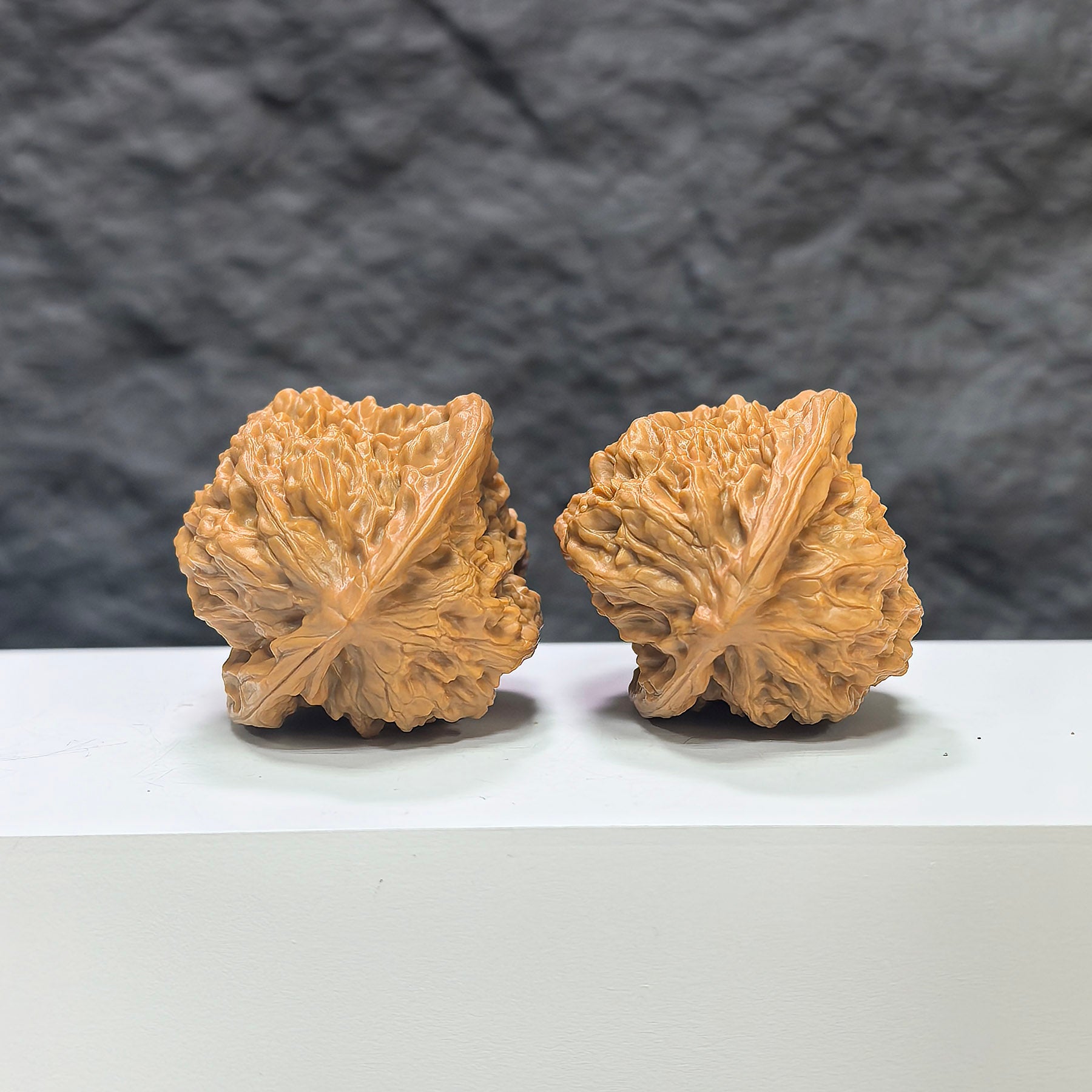 Pair of Wenwan Art Arhat Head round-profile Wenwan walnuts, 41mm x 38mm, showcasing detailed carved walnut heads.