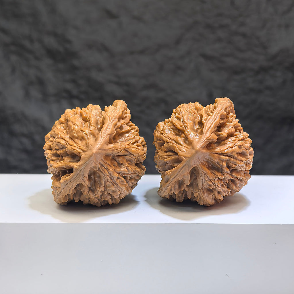 Pair of Classic Scholar Wenwan Walnuts by Wenwan Art, featuring peach heart carved pattern, 47mm x 43mm, hand-matched walnut stones.