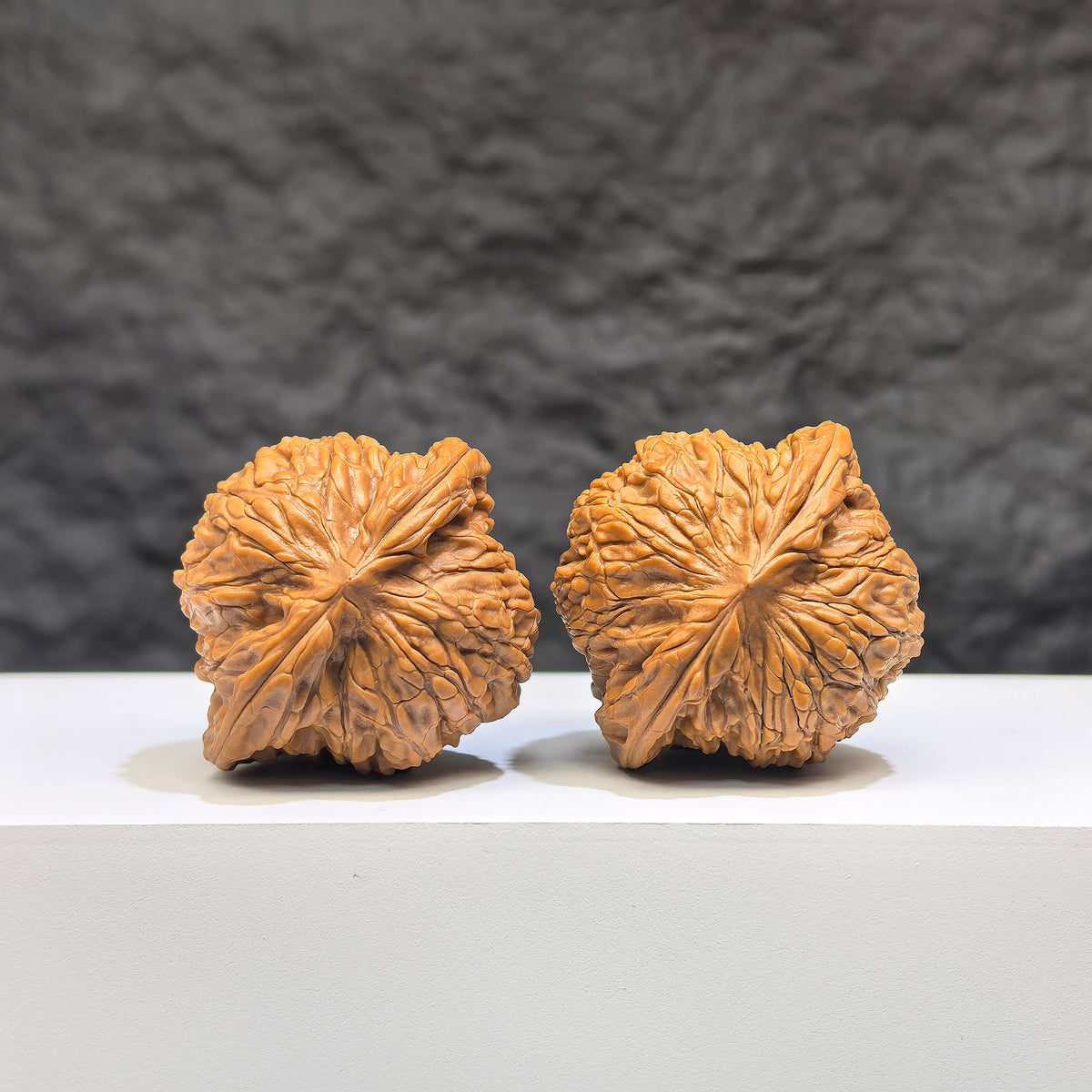 Pair of Wenwan Art Millstone Classic Wenwan walnuts, 38mm x 34mm, showcasing detailed carved patterns and smooth polished surfaces.