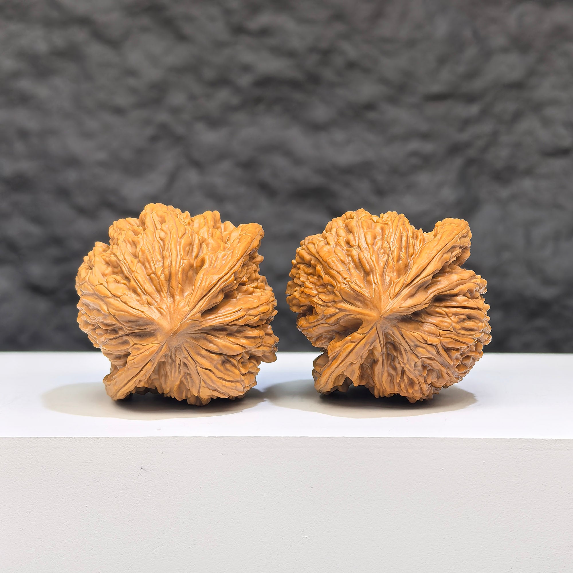 Pair of Yuhua Stone Wenwan walnuts from Wenwan Art, 36mm x 35mm, showcasing polished, natural stone textures and intricate details.