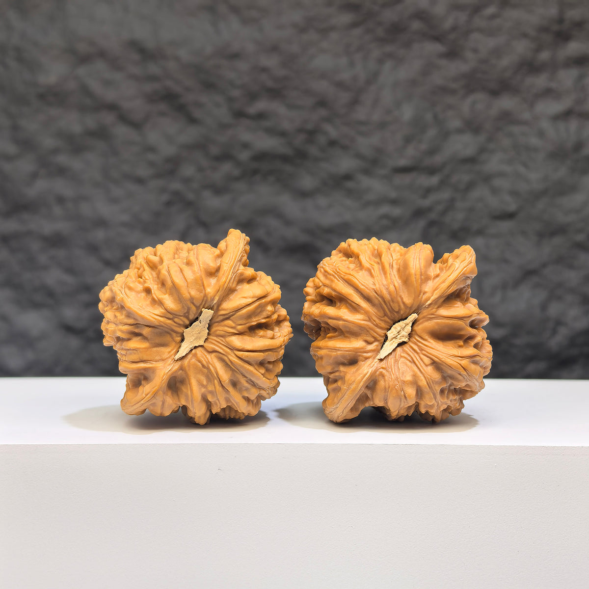 Pair of Wenwan Art "Ruby" classic Wenwan walnuts, 41mm x 37mm, featuring deep red gemstone-like appearance and smooth polished surface.