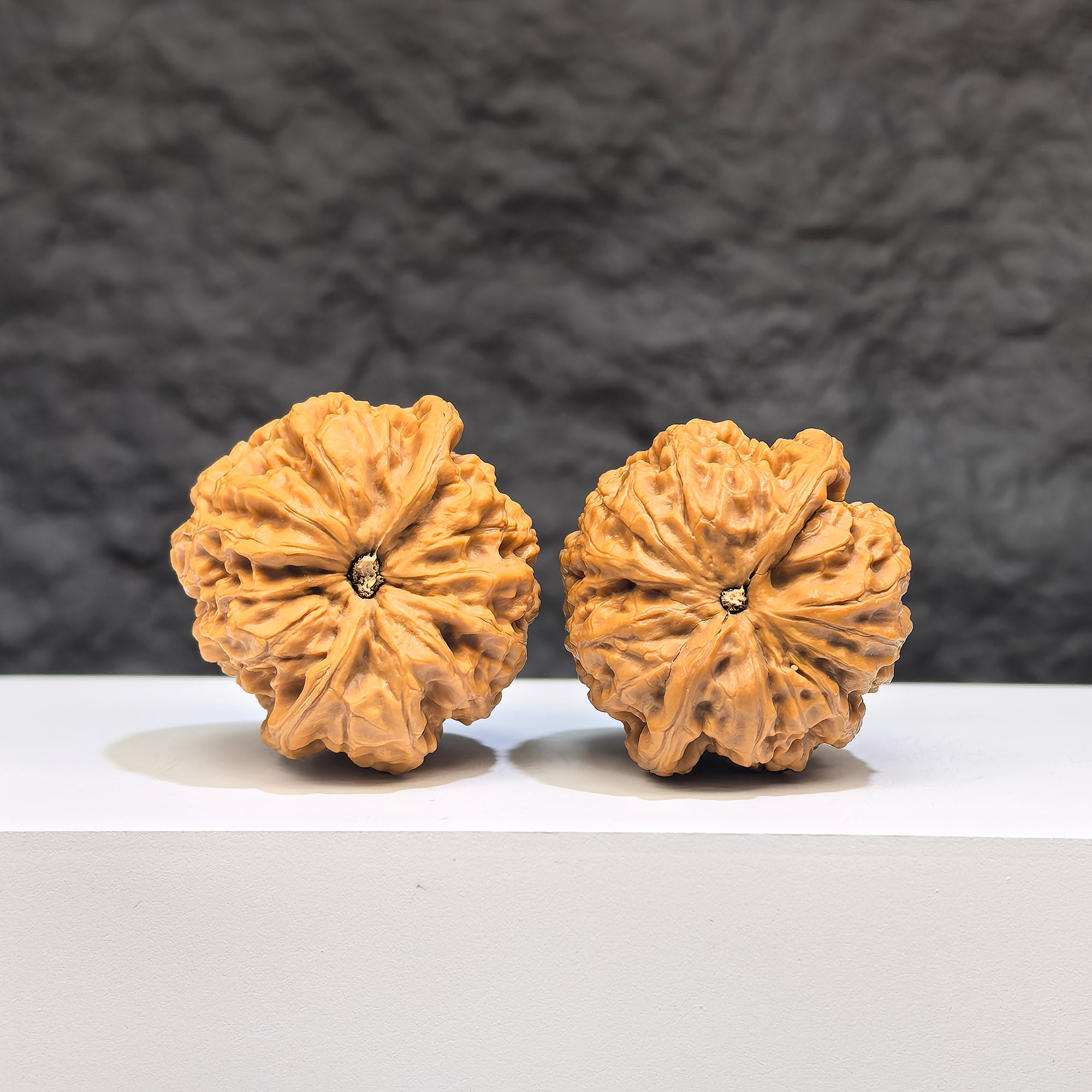 Pair of Wenwan Art Pocket Yuhua Stone miniature walnuts, 34mm x 33mm, showing detailed natural stone textures and polished surfaces.