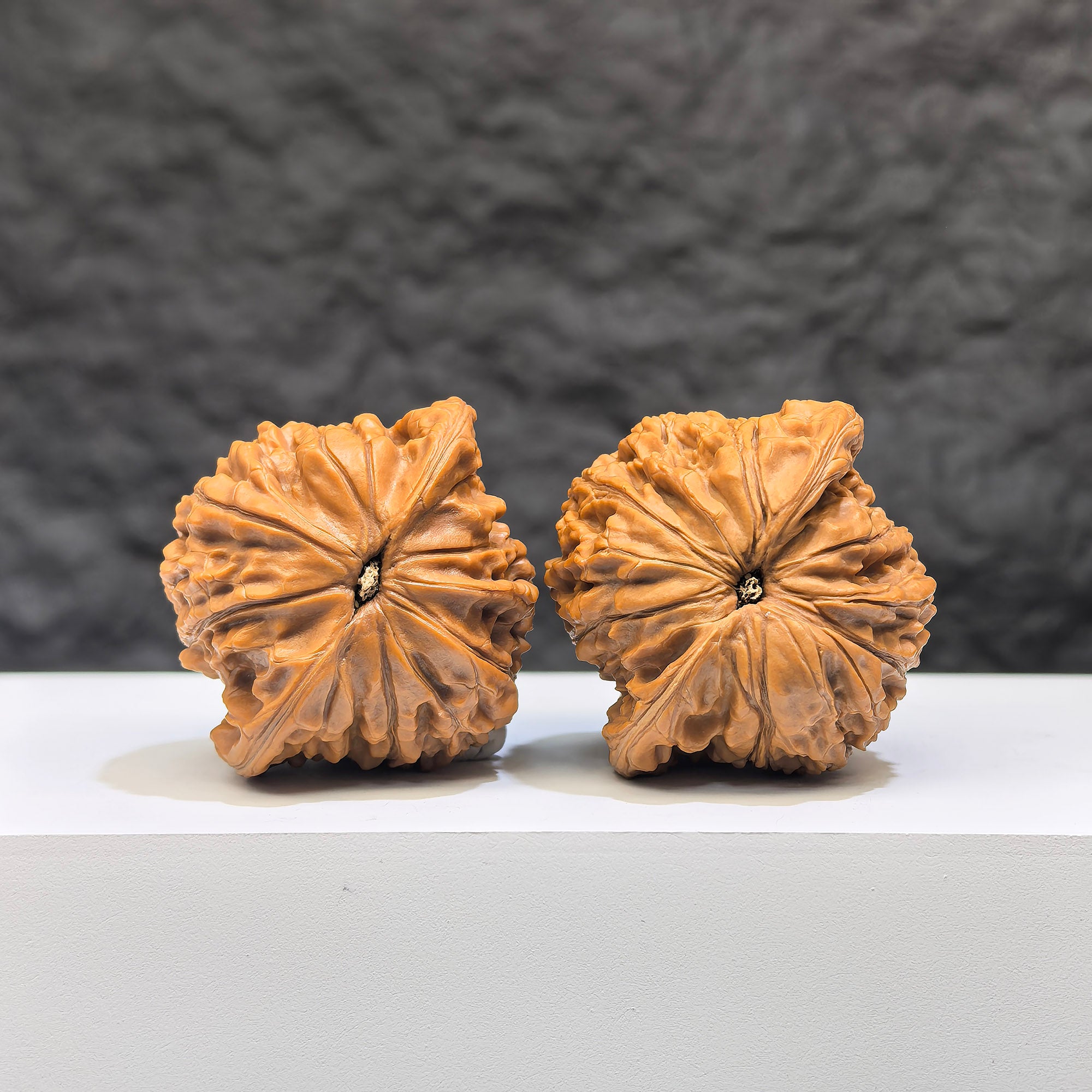 Pair of Wenwan Art Millstone Classic Wenwan Walnuts, 38mm x 34mm, showing detailed carved designs and natural walnut texture.
