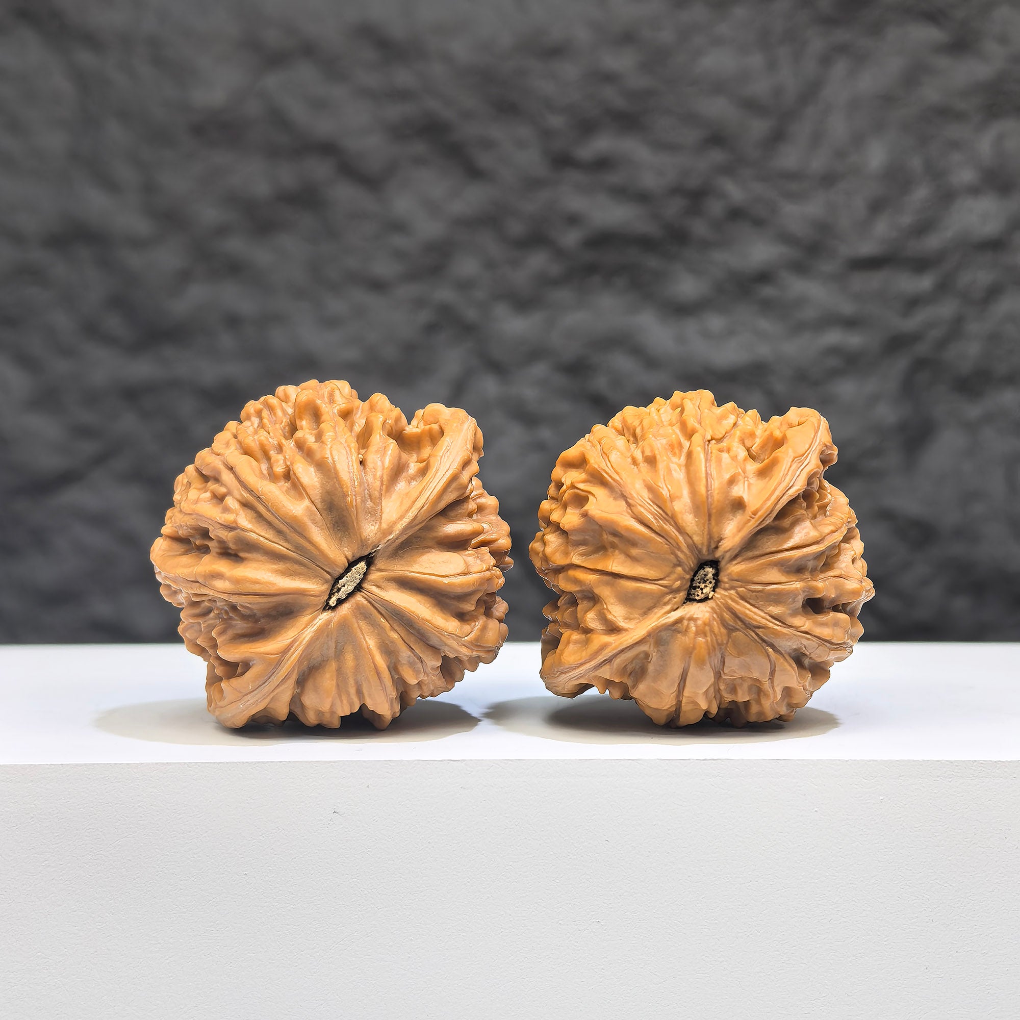 Pair of Wenwan Art Pocket Symmetrical Millstone miniature walnuts, 36mm x 33mm, featuring detailed carvings and natural wood grain.