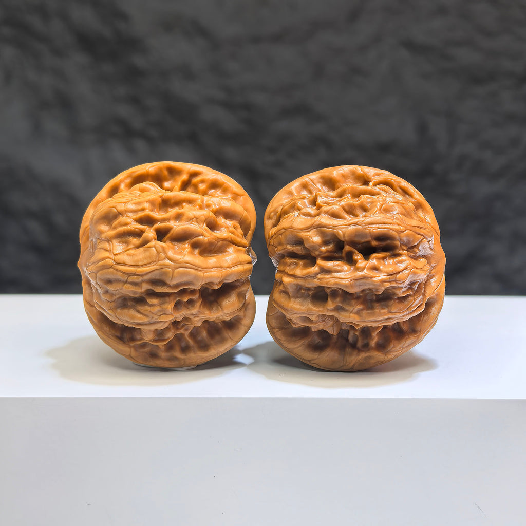 Pair of Wild Wolf Yelang Deep-Carved Wenwan walnuts from Wenwan Art, 38mm x 36mm, showcasing intricate carvings on walnut surfaces.